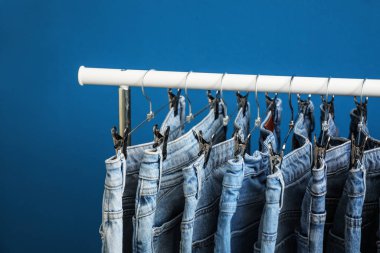 Mavi arka planda şık kot pantolon ile rafa kaldırın, yakın plan