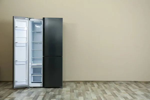 Modern refrigerator near beige wall, space for text — Stock Photo, Image
