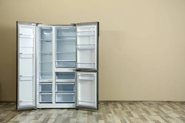 Moderno refrigerador cerca de la pared beige, espacio para texto — Foto de Stock