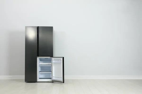 Moderno refrigerador cerca de la pared gris claro. espacio para texto — Foto de Stock