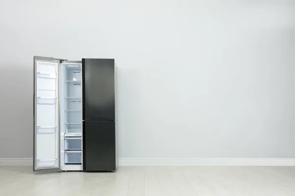 Modern refrigerator near light grey wall. space for text — Stock Photo, Image