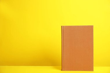Sarı arka planda ciltli kitap. Tasarım için boşluk