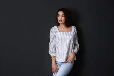 Siyah arka planda günlük kıyafetli güzel bir kadın.