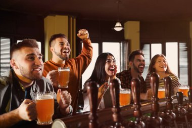 Group of friends watching football in sport bar