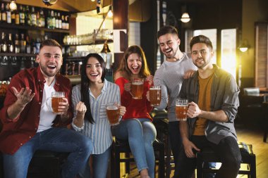 Group of friends watching football in sport bar