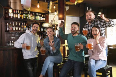 Group of friends watching football in sport bar