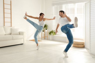 Güzel, genç bir çift oturma odasında dans ediyor.