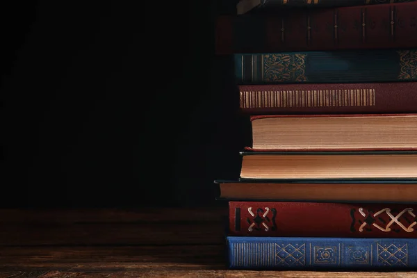 Kolekcja różnych książek na drewnianym stole przed ciemnym backg — Zdjęcie stockowe