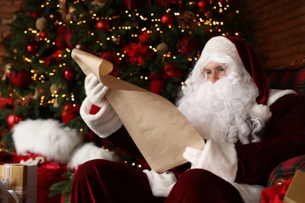 Santa Claus Czytanie Listy Życzeń Fotelu Pobliżu Choinki — Zdjęcie stockowe