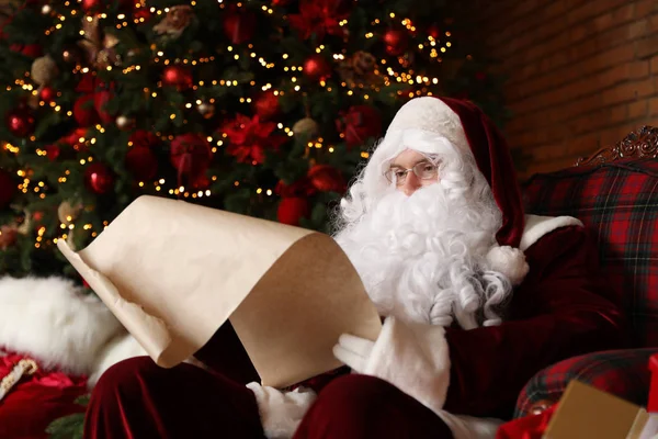 Santa Claus Czytanie Listy Życzeń Fotelu Pobliżu Choinki — Zdjęcie stockowe