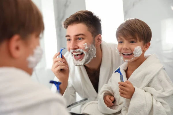 Tata golenie i syn naśladując go w łazience — Zdjęcie stockowe