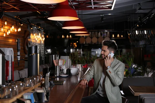 Młody właściciel firmy rozmawia przez telefon w kawiarni — Zdjęcie stockowe