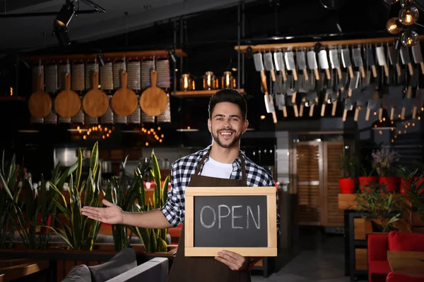 Młody właściciel firmy trzyma znak Open w swojej kawiarni — Zdjęcie stockowe