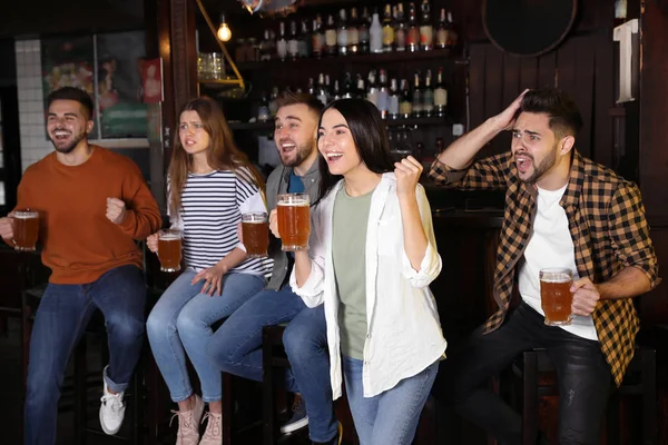 Group of friends watching football in sport bar — Stok fotoğraf