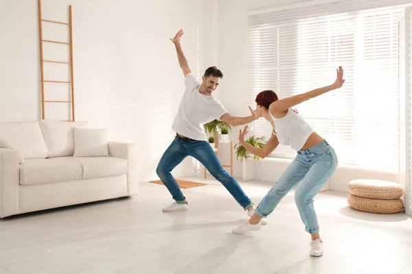 Красивая молодая пара танцует в гостиной — стоковое фото