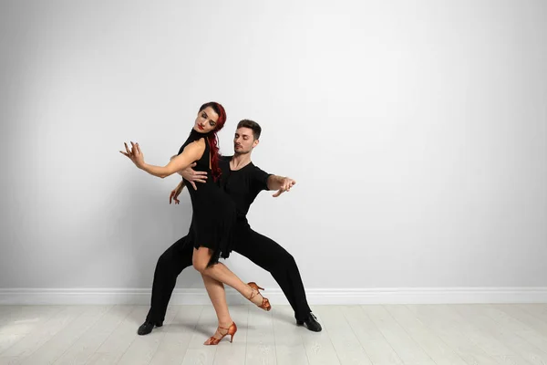Красива молода пара танцює біля світлої стіни. Простір для тексту — стокове фото