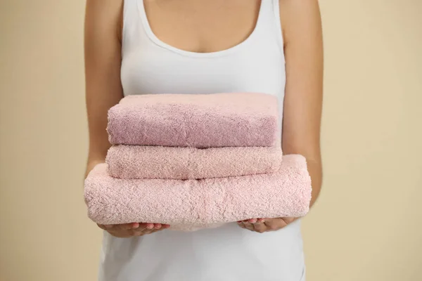 Kobieta Trzymająca Świeże Ręczniki Beżowym Tle Zbliżenie — Zdjęcie stockowe