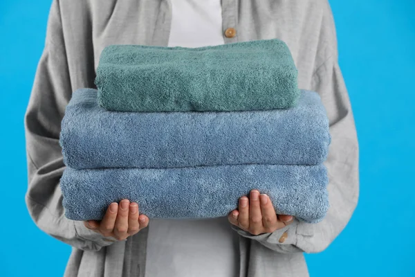 Woman Holding Fresh Towels Light Blue Background Closeup — 스톡 사진
