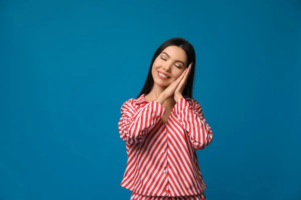 Mulher asiática bonita vestindo pijama no fundo azul. Dormitório — Fotografia de Stock