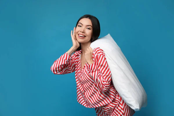 Vacker asiatisk kvinna med kudde på blå bakgrund. Sängdags — Stockfoto