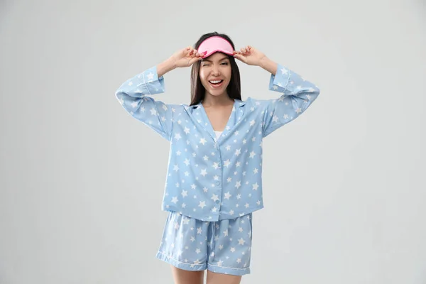 Piękna Azjatka w piżamie i śpiącej masce na świetle — Zdjęcie stockowe