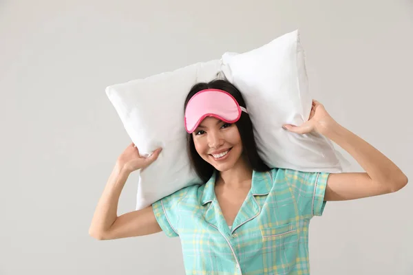 Vacker asiatisk kvinna med kudde på ljusgrå bakgrund. Sängkläder — Stockfoto