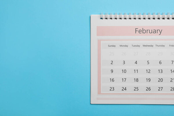 Февраль календарь на голубом фоне, вид сверху. Пространство для текста
