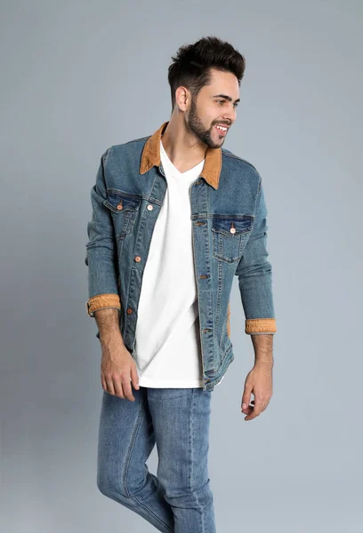 Ung man i snygga jeans på grå bakgrund — Stockfoto