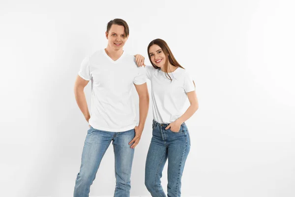 Jovem casal em jeans elegantes perto da parede branca — Fotografia de Stock