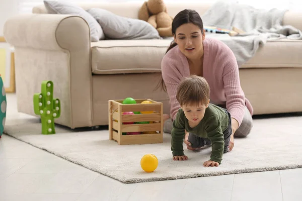 Young nanny and cute little baby playing with toys at home — Stock Photo, Image