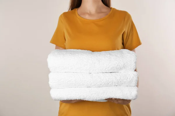 Kobieta Trzymająca Świeże Ręczniki Jasnym Tle Zbliżenie — Zdjęcie stockowe