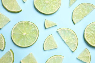 Açık mavi zemin üzerinde sulu taze limon dilimleri, düz uzanmış.