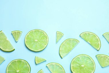 Açık mavi arka planda sulu taze limon dilimleri, düz. Metin için boşluk