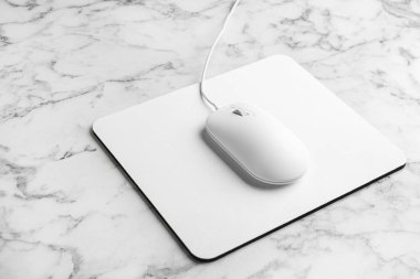 Beyaz mermer masa üzerinde modern kablolu optik fare ve ped