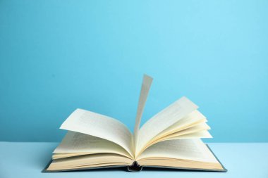 Açık mavi arkaplan üzerine eski bir cilt kitabı aç