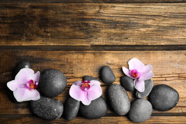 Orkide çiçekli taşlar ve tahta zemin üzerinde yazı için boşluk, düz yatış. Zen yaşam tarzı