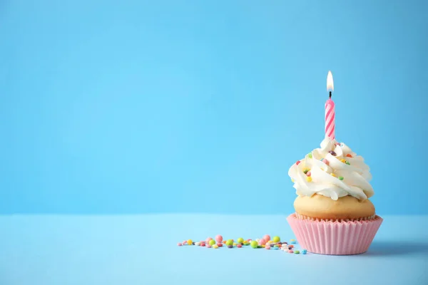 Delicioso cupcake de cumpleaños con vela sobre fondo azul claro . —  Fotos de Stock