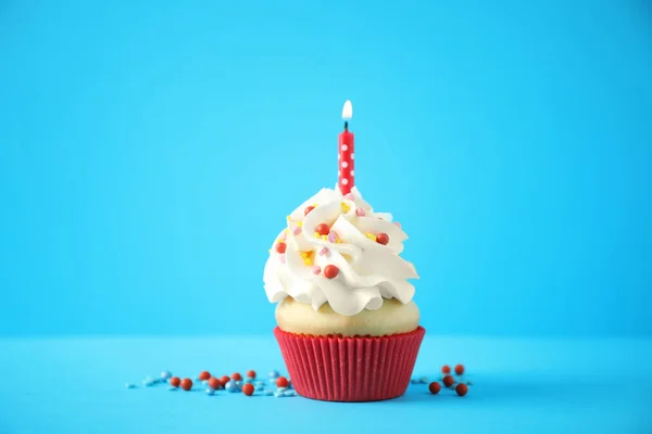 Lahodný narozeninový dortík se svíčkou na světle modrém pozadí — Stock fotografie