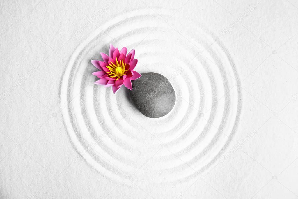 Zen garden. Beautiful lotus flower and stone on white sand, flat lay