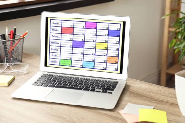 Ofisinde takvim uygulaması olan modern bir laptop.