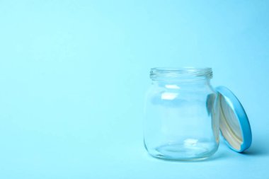 Açık mavi arkaplanda boş cam kavanoz aç, metin için boşluk