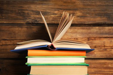 Ahşap zemin üzerine renkli kitap yığını