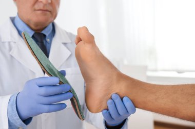 Klinikte erkek ortopedi uzmanı, hastanın ayağına uygun taban, clo