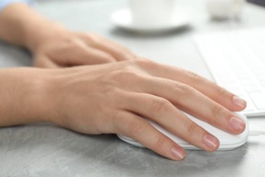 Açık gri mermer masada bilgisayar faresi kullanan kadın, yakın plan.