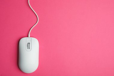 Pembe arka planda kablolu bilgisayar faresi, üst görüntü. Metin için boşluk