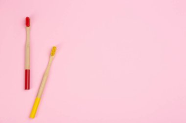 Pembe arka planda bambudan yapılmış diş fırçaları. Boşluk 