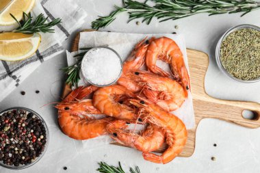 Limon ve baharatla servis edilen lezzetli pişmiş karidesler gri mermer masada, düz yerde.