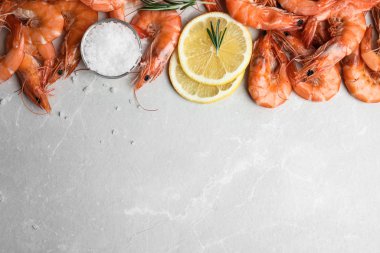 Biberiyeli nefis pişmiş karides, gri mermer masada tuz ve limon, düz yatak. Metin için boşluk