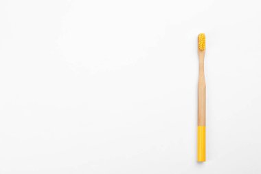 Sarı tüylü bambu diş fırçası beyaz, üstte izole edilmiş.