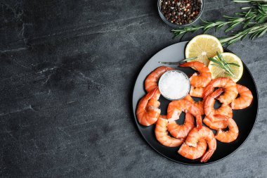 Koyu gri masada limonlu ve tuzlu nefis pişmiş karidesler. Metin için boşluk